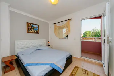 a bedroom with a bed and a large window at MC Apartments in Ulcinj