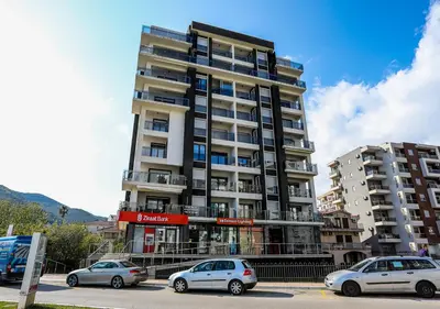 a tall building with cars parked in front of it at Budva Bay Breeze Apartments in Budva