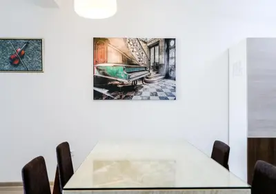 a table with chairs and a painting on the wall at Budva Bay Breeze Apartments in Budva