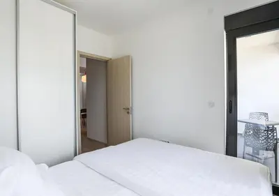 a bedroom with a white bed and a large mirror at Budva Bay Breeze Apartments in Budva