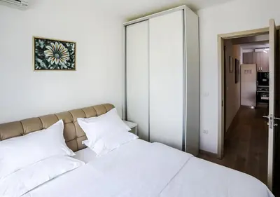 a bedroom with a large white bed with white pillows at Budva Bay Breeze Apartments in Budva