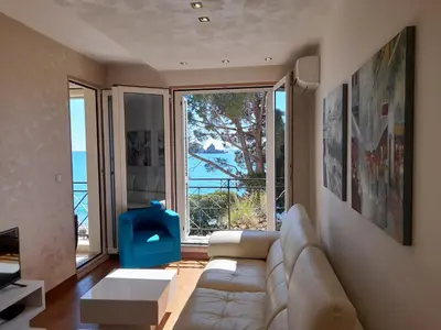 a living room with a couch and a large window at LuxBeachFront in Petrovac na Moru