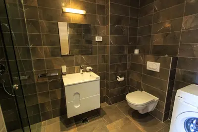 a bathroom with a toilet and a sink and a mirror at LuxBeachFront in Petrovac na Moru