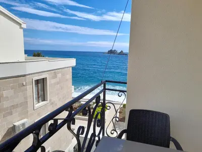 a balcony with a table and a view of the ocean at LuxBeachFront in Petrovac na Moru