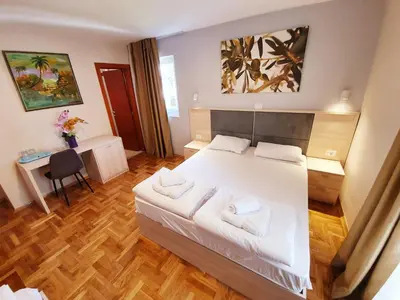 a bedroom with a large white bed with two pillows at Apartments Pier in Budva