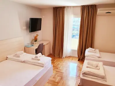 a hotel room with two beds and a window at Apartments Pier in Budva