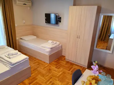 a small room with two beds and a table at Apartments Pier in Budva