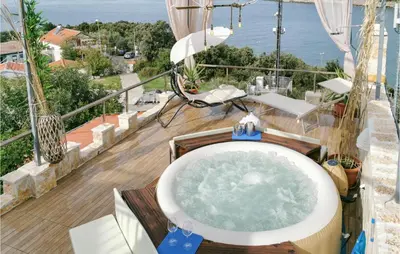 a bath tub on a balcony with a view of the ocean at Beautiful Apartment In Utjeha in Utjeha