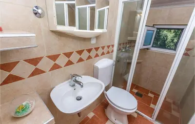 a bathroom with a toilet and a sink and a shower at Beautiful Apartment In Utjeha in Utjeha