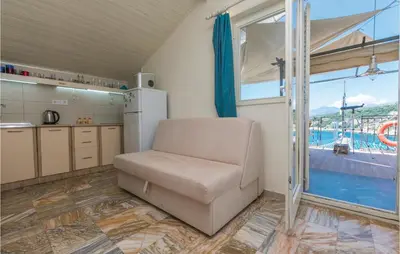 a room with a chair and a kitchen with a pool at Beautiful Apartment In Utjeha in Utjeha
