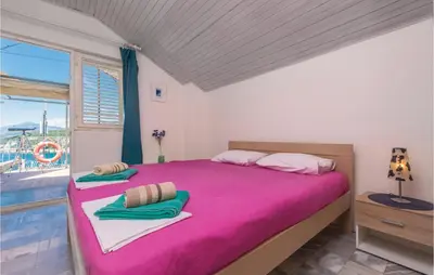 a bedroom with a pink bed and a window at Beautiful Apartment In Utjeha in Utjeha