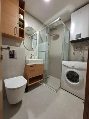 a bathroom with a washing machine and a washer at Pg Apartment in Podgorica