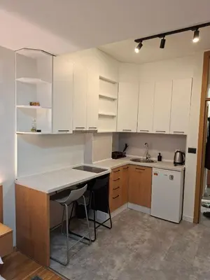 a kitchen with white cabinets and a counter top at Pg Apartment in Podgorica