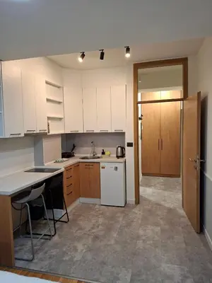 a kitchen with white cabinets and a white refrigerator at Pg Apartment in Podgorica
