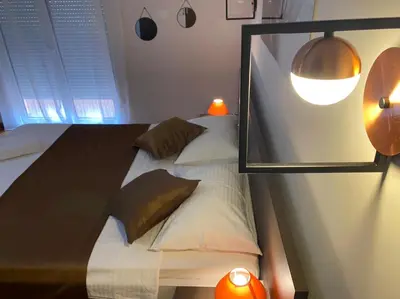 a bedroom with a bed with two pillows and a mirror at Pejovic Residence Budva in Budva