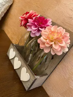 a vase filled with pink flowers and two hearts at Pejovic Residence Budva in Budva