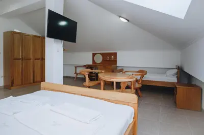 a room with a bed and a table and a couch at Eco Winery Lipovac Apartments in Cetinje