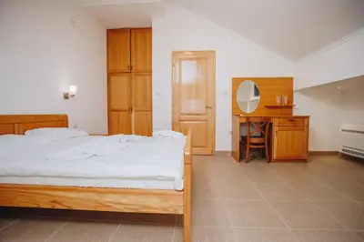 a bedroom with a bed and a desk with a mirror at Eco Winery Lipovac Apartments in Cetinje
