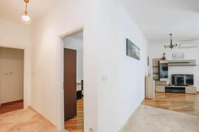 an open living room with white walls and wooden floors at Apartment near Ponta Nova of Rafailovici in Becici