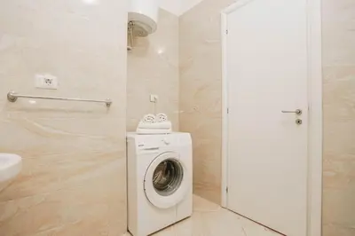 a bathroom with a washing machine and a toilet at Apartment near Ponta Nova of Rafailovici in Becici