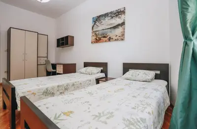 a bedroom with two beds and a painting on the wall at Apartment near Ponta Nova of Rafailovici in Becici