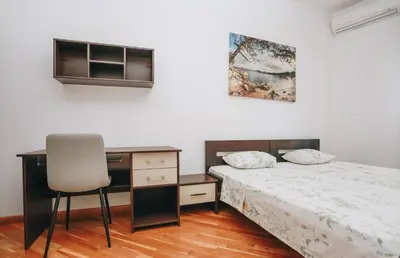 a bedroom with a bed and a desk and a chair at Apartment near Ponta Nova of Rafailovici in Becici