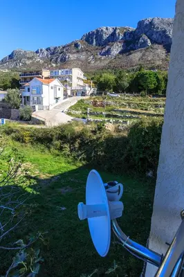 a blue satellite dish on the side of a house at Villa Narcissus Montenegro KO Sveti Stefan in Sveti Stefan