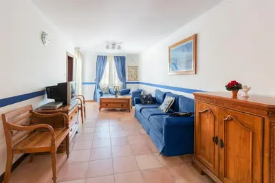 a living room with a blue couch and a tv at Apart-hotel Villa Lav in Tivat
