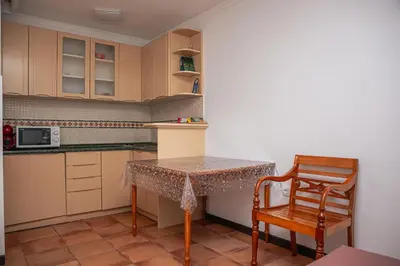 a small kitchen with a table and a chair at Apart-hotel Villa Lav in Tivat