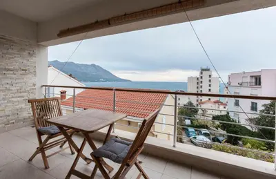 a balcony with a wooden table and two chairs at Apartment-Hotel Vila Petrovic-Becici in Budva