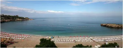 a beach with chairs and umbrellas and the ocean at Top see in Bar