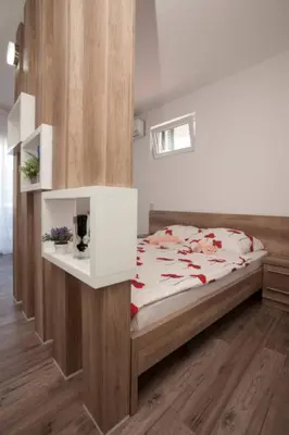a bedroom with a bed and shelves in it at B&T Apartments in Budva