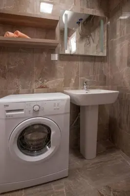 a bathroom with a washing machine and a sink at B&T Apartments in Budva