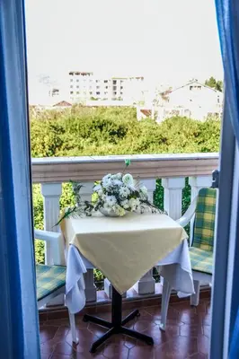 a table with a flower arrangement on a balcony at Eldorado Apartments in Ulcinj