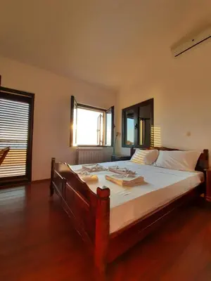 a bedroom with a large bed with white sheets at Villa Lipski in Sveti Stefan