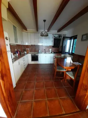 a kitchen with a tiled floor and a table at Villa Lipski in Sveti Stefan