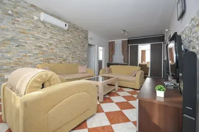 a living room with couches and a brick wall at D&D Apartment 1 in Budva