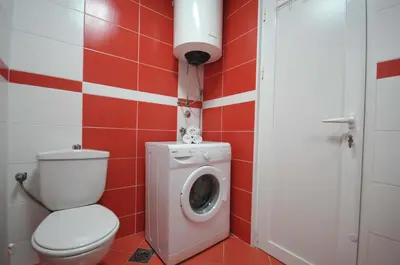 a bathroom with a toilet and a washing machine at D&D Apartment 1 in Budva