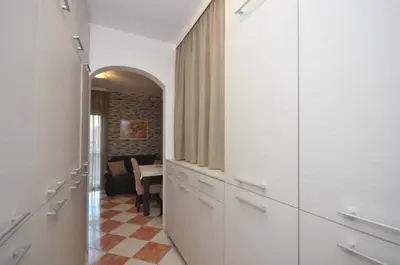 a hallway with white cabinets and a table in a room at D&D Apartments 3 in Budva