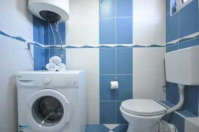 a bathroom with a washing machine and a toilet at D&D Apartments 3 in Budva