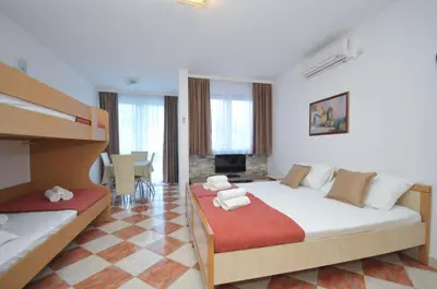 a bedroom with two beds and a living room at D&D Apartments 3 in Budva