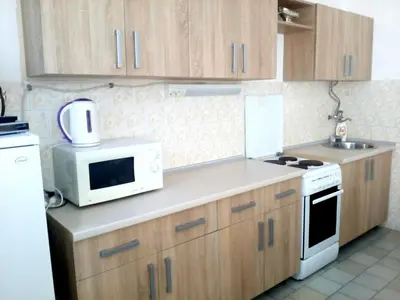 a kitchen with wooden cabinets and a white microwave at Villa Marija Ulcinj in Ulcinj