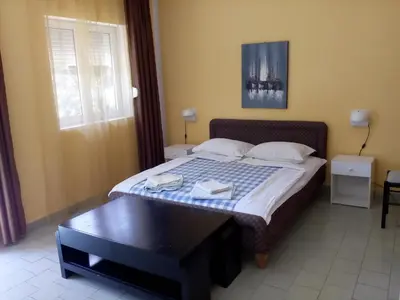 a bedroom with a bed with a table and a window at Villa Marija Ulcinj in Ulcinj