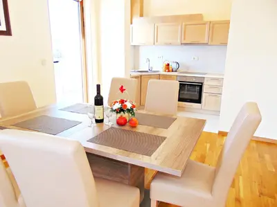 a kitchen with a dining room table with a bottle of wine at ApartHotel Belvedere Residence Becici Budva in Budva