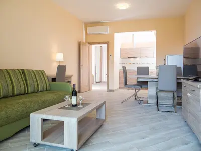 a living room with a green couch and a table at ApartHotel Belvedere Residence Becici Budva in Budva