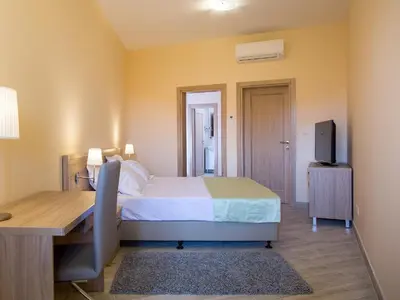 a bedroom with a bed and a desk and a television at ApartHotel Belvedere Residence Becici Budva in Budva