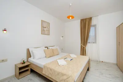 a bedroom with a bed in a white room at Arvala Apartments in Budva
