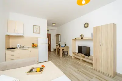 a kitchen and a living room with a table and a refrigerator at Arvala Apartments in Budva