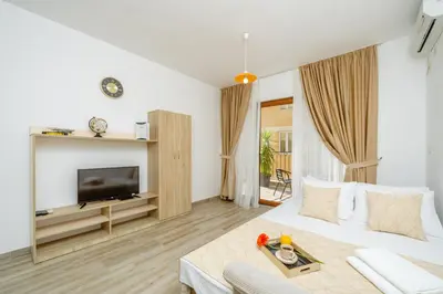 a living room with a white couch and a tv at Arvala Apartments in Budva