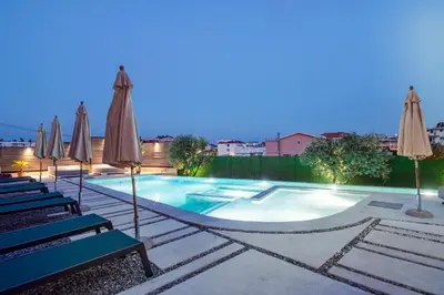 a swimming pool with chairs and umbrellas at Apartments Kan in Ulcinj